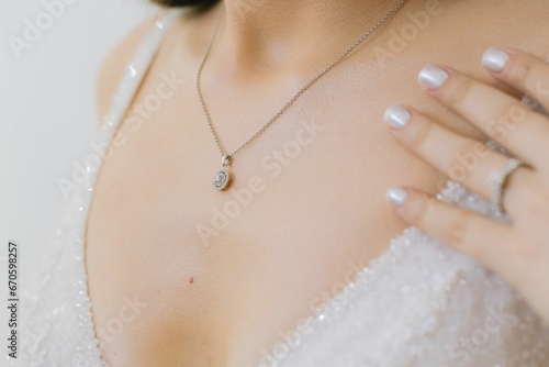 Beautiful woman wearing a white bridal gown with a delicate necklace