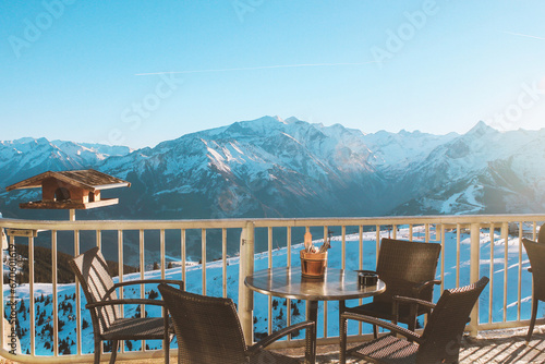 Balcony with table and chairs overlooking the snow-capped mountains of the Zell am See ski resort in Austria. Sunny winter day, vacation in the Alps. Relaxing photo without people © svetakhovrina