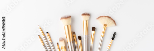 Collection of beautiful makeup brushes on white background with copyspace. Top view