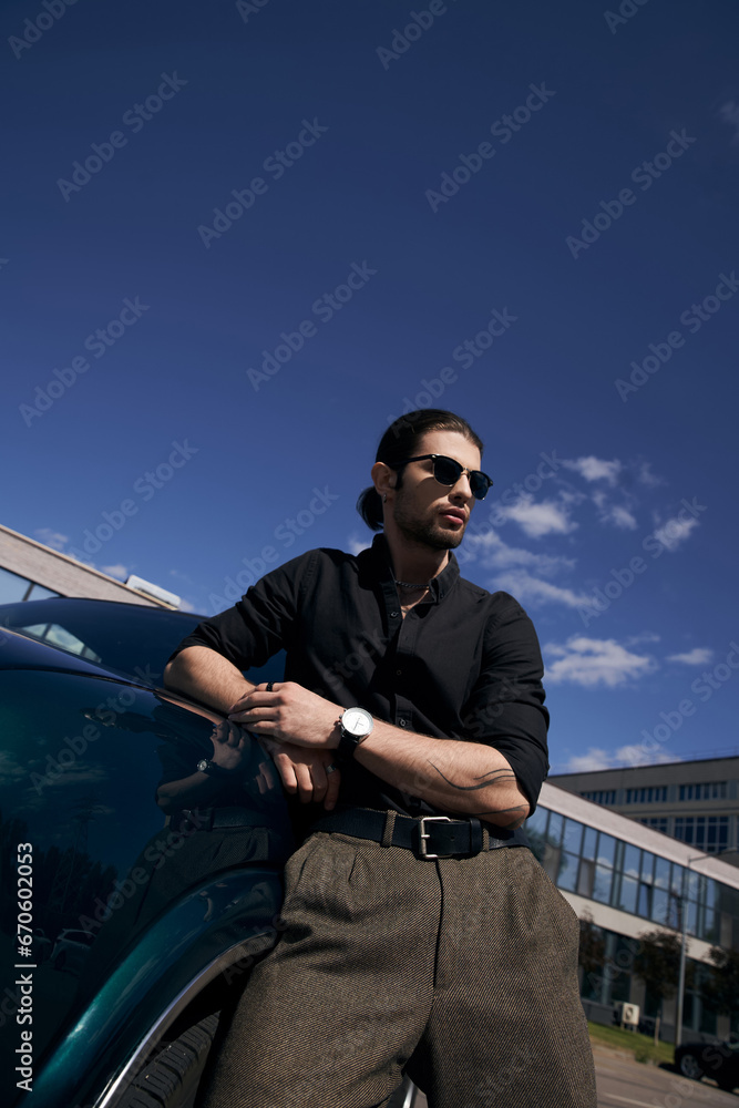 elegant sexy male model with ponytail in black casual outfit posing next to his car, outdoor elegant sexy male model with ponytail in black casual outfit posing next to his car, outdoor