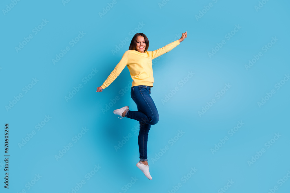Carefree woman jumping against blue background Carefree woman jumping against blue background