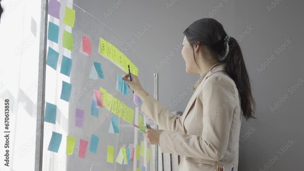 Young entrepreneur, Asian accountant holding a post-it note on glass, creative concept of Asian person, young entrepreneur at work Young entrepreneur, Asian accountant holding a post-it note on glass, creative concept of Asian person, young entrepreneur at work