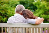 Park, back view or mature couple on bench for support, trust or hope in commitment together in nature. Hug, garden or senior man bonding to relax with woman on anniversary for love, wellness or care