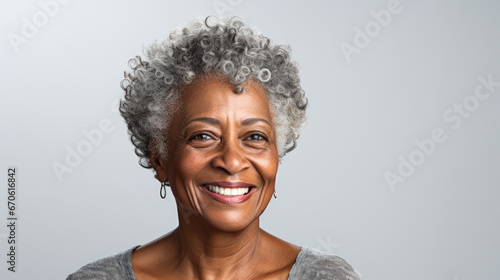 This close-up studio photo features a senior African American woman with grey hair, isolated on a white background, highlighting her elegance and character.