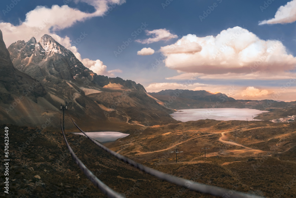 Power cord lines hanging in first place on a large view Peruvian landscape with epic sky, two lakes into the mountains, and many roads in a very detailed land