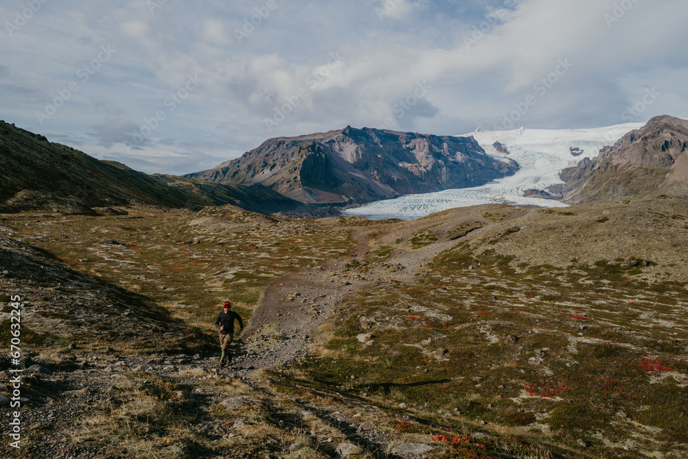 Man running next to the Svinafellsjokull glacier in Iceland