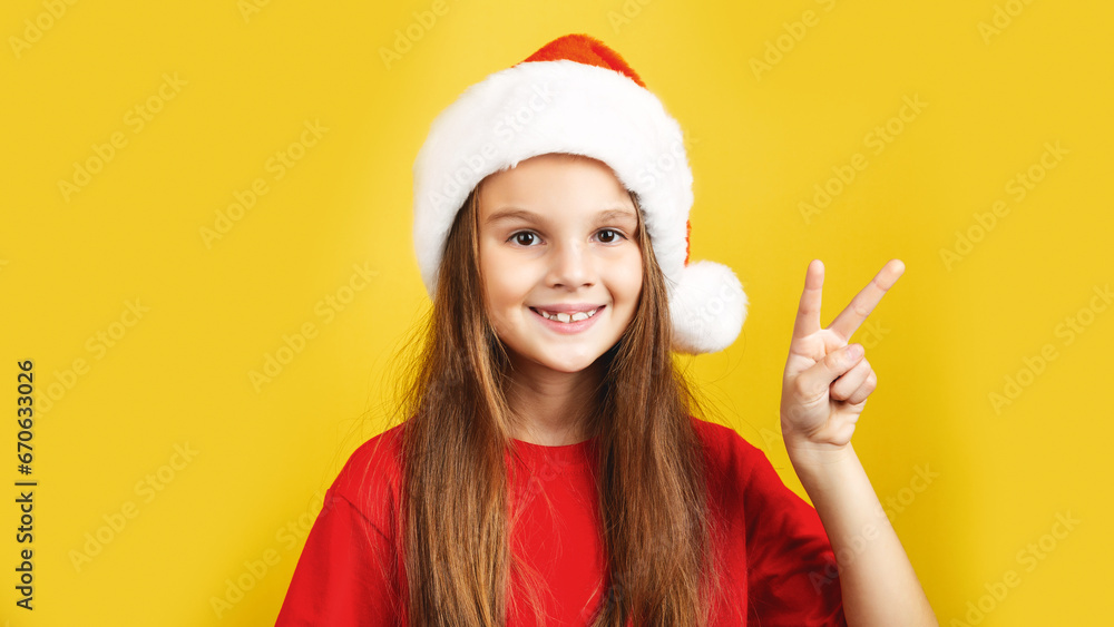 Kid dressed in red Santa Claus hat, Portrait of little girl smile. Concept of holiday Christmas Xmas day or Happy new year, studio shot isolated on yellow background Kid dressed in red Santa Claus hat, Portrait of little girl smile. Concept of holiday Christmas Xmas day or Happy new year, studio shot isolated on yellow background
