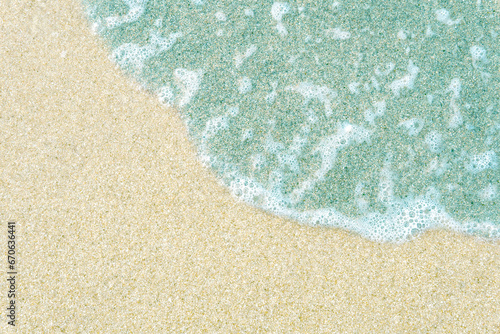 Background with emerald wave on white sand.