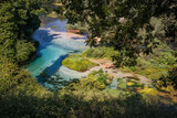 Blue Eye Natural Monument in Albania. Blue River  and Green Environment during Sunny Day in Muzinë.