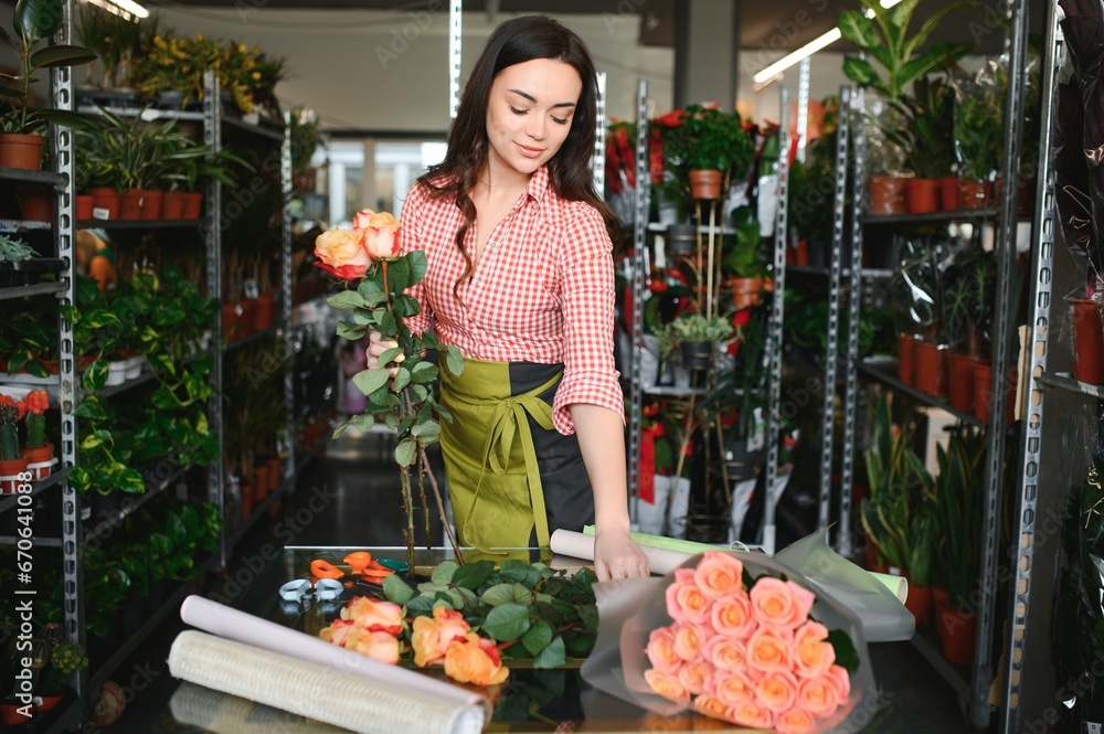 happy girl gardener in the flower shop make bouquets for a holiday. Lifestyle flower shop.