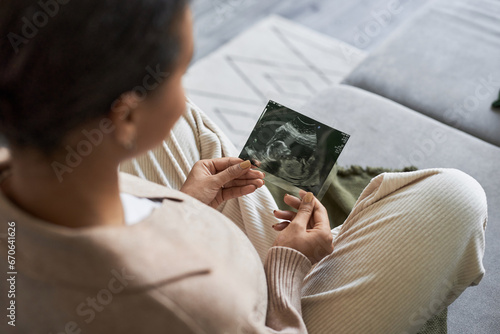 Stampa su tela Portrait of pregnant young woman holding ultrasound picture of baby and enjoying