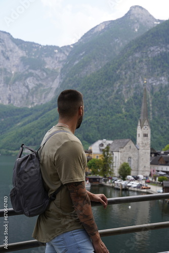 Unrecognizable young male tourist visiting the beautiful village Hallstatt in Austria