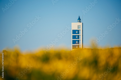 A modern lighthouse stands out in a blurry foreground photo
