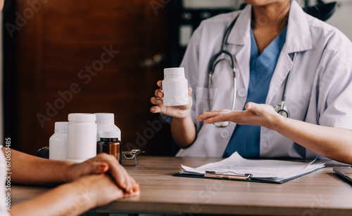 Pharmacist explaining prescription medication to woman in the pharmacy for pharmaceutical healthcare treatment. Medical  counter and female chemist talking to patient on medicine in clinic dispensary