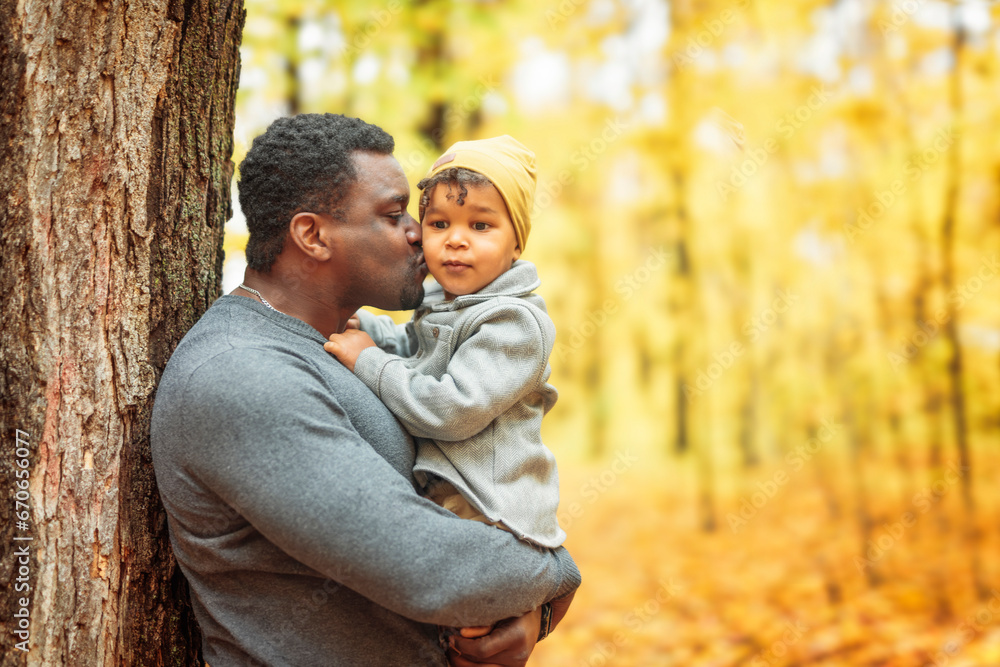 Fototapeta premium Father and son having fun in autumn park