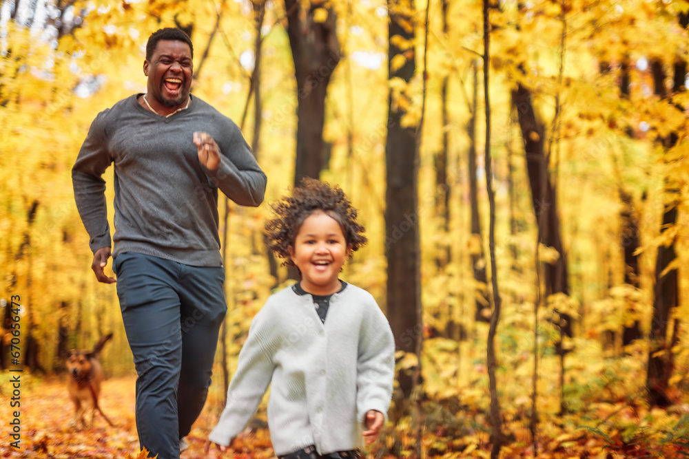 Father and daughter having fun running in autumn park Father and daughter having fun running in autumn park