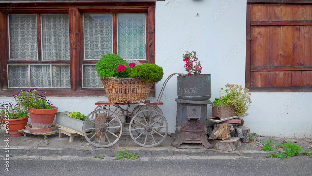 Quaint tradtional European residential decoration in Swiss street. Flower pots and rural accessories on display in cottage Switzerland
