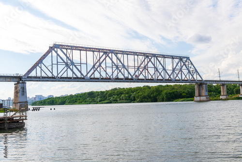 Side view of empty old metal railway bridge standing on Don river in a summer cloudy day. Soft focus. General architecture theme.