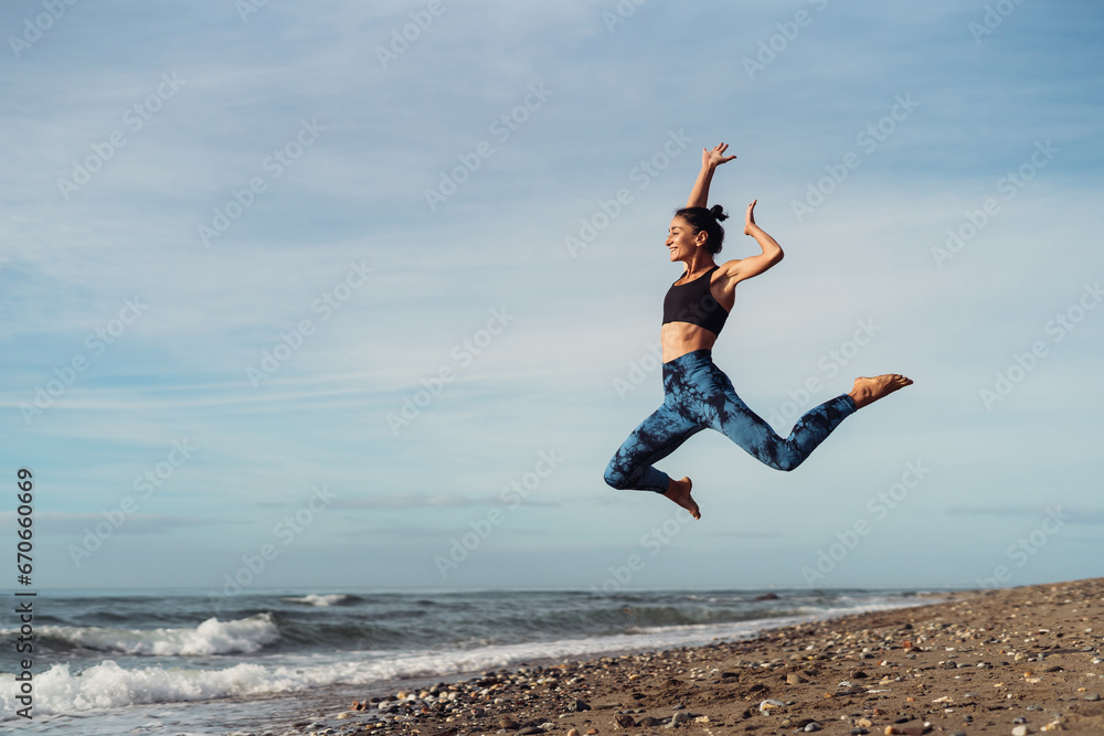 The girl is doing fitness on the seaside.