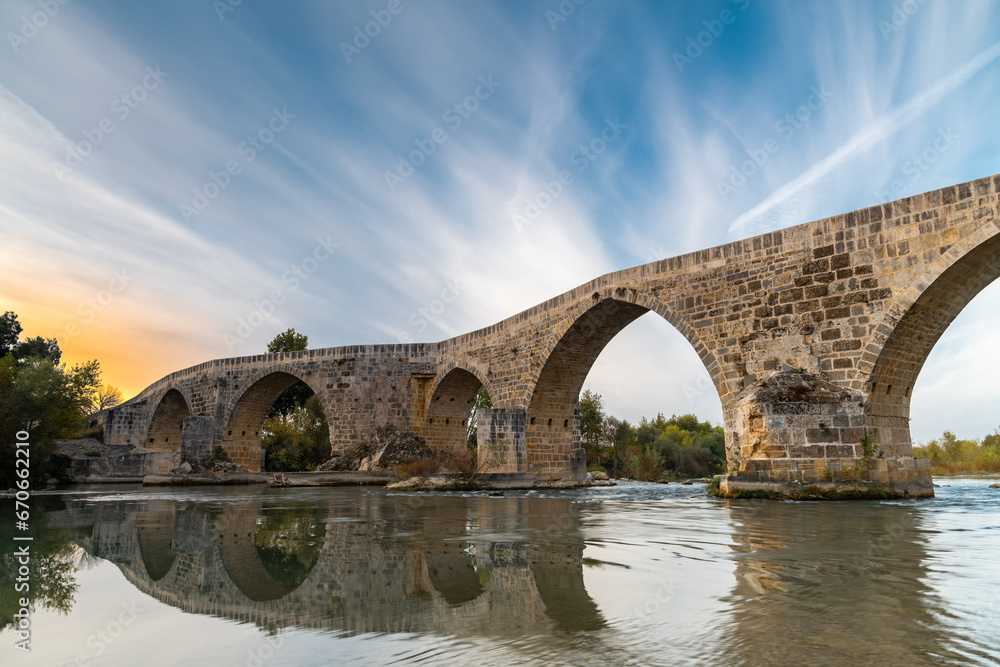 The historical Aspendos Bridge over Koprucay at sunrise in Antalya Turkey