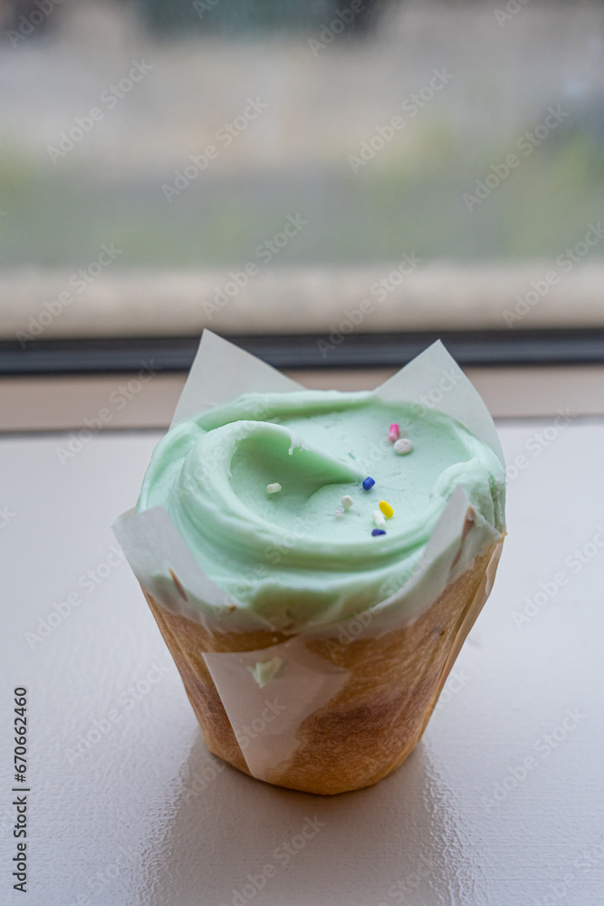 Closeup fancy cupcake, green frosting over vanilla cupcake