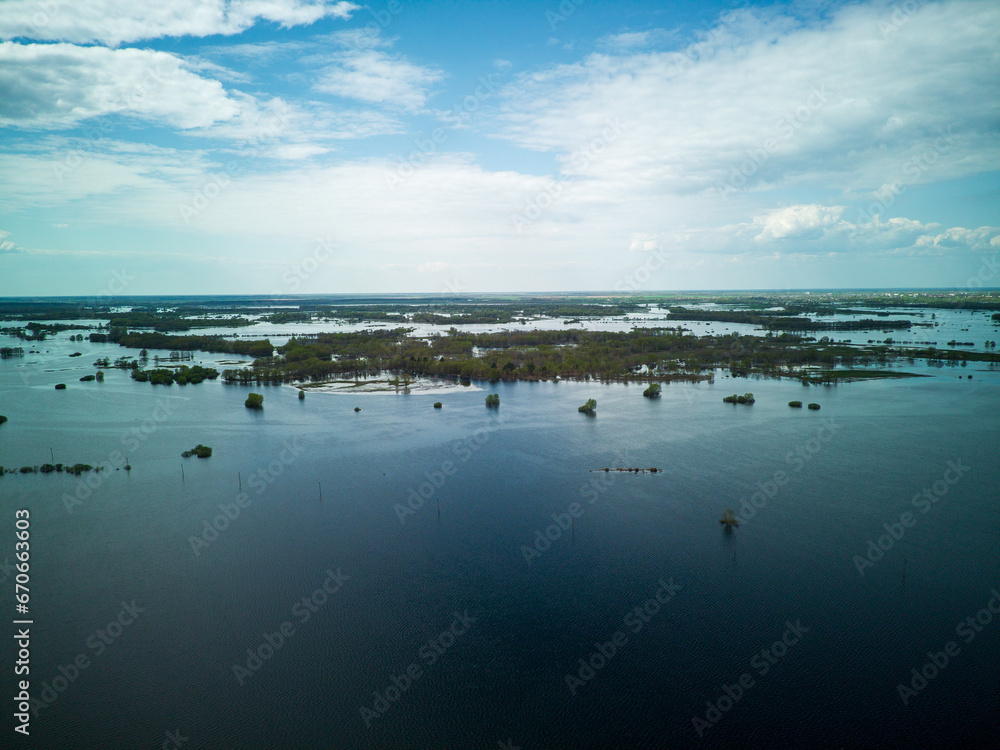 Flooded country roads and flooded meadow. Flight over a flooded country road in a beautiful meadow at sunset. Aerial view. Flooded country roads and flooded meadow. Flight over a flooded country road in a beautiful meadow at sunset. Aerial view.