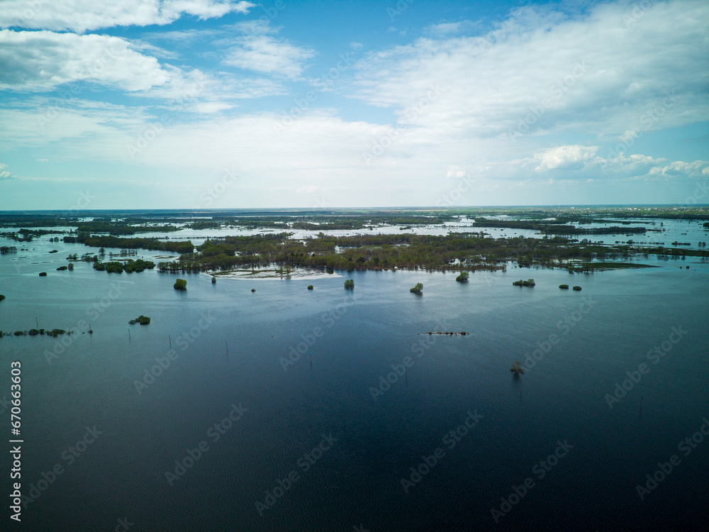 Flooded country roads and flooded meadow. Flight over a flooded country road in a beautiful meadow at sunset. Aerial view.