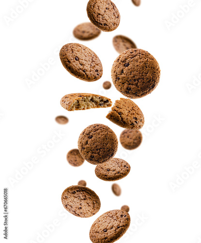 Oatmeal cookies with chocolate pieces fall in space. Rear surround light. Isolated on white