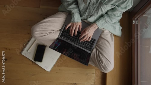 Top View of Lady in Homewear Sitting cross legged and Typing Text on laptop in Cozy Room at COVID-19 Pandemic. Self-isolation 
