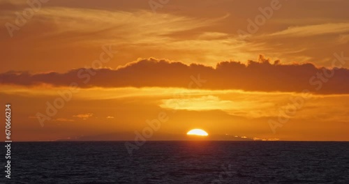 Sun setting down over ocean cinematic long real time video 4K. Beautiful nature landscape background, sunset evening dusk twilight sundown, open horizon orange red skies, scenic beauty golden hour.