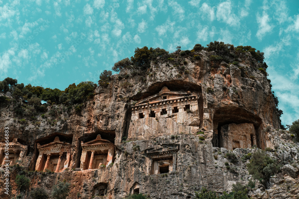 Dalyan Turkey ancient Lycian caved Temple tombs , green trees, amazing nature of Koycegiz, blue sky with white small clouds, popular tourist holiday destination
