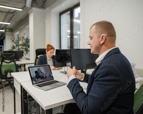 Business partners are talking in sign language to a video call. Two men at a remote business meeting.