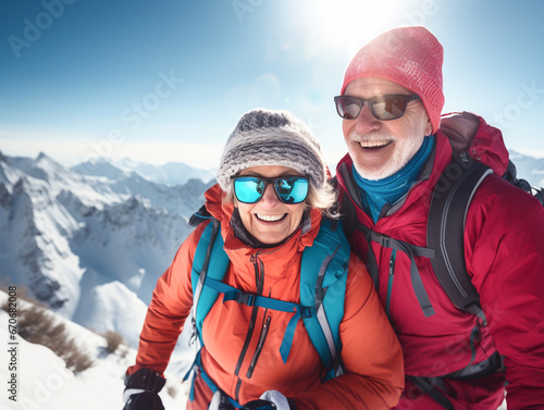 Senior couple in winter clothes on the background of snowy mountains.