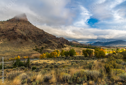 Landscape of an Absaroka Mountain Valley with Early Morning Light in Fall Color on a Cloudy Autum Day near Cody, Wyoming, USA photo