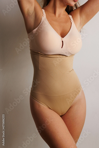 Plus size pretty model in correcting figure (body) stretch beige shorts.
Beautiful lady with big breasts and small waist wear underwear to correct her figure. Woman with long hair in bedroo in panties