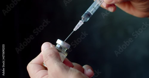 A syringe with medicine inside and aspirating medicine from another vial increases the amount of medicine to the desired dosage.Syringe with liquid being drawn into syringe.Testosterone.