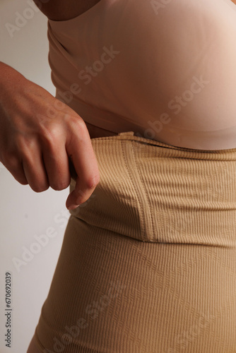 Plus size pretty model in correcting figure (body) stretch beige shorts.
Beautiful lady with big breasts and small waist wear underwear to correct her figure. Woman with long hair in bedroo in panties