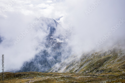  The mountains, shrouded in a delicate veil of clouds, create an ethereal and mysterious landscape. © Igor