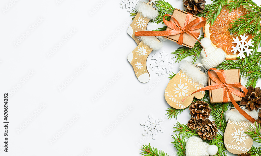 fir branches, gift boxes, pine cones and Christmas decorations on a light gray background, top view fir branches, gift boxes, pine cones and Christmas decorations on a light gray background, top view