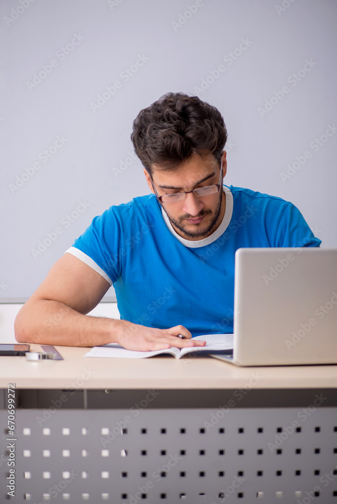 Young male student in front of whiteboard Young male student in front of whiteboard