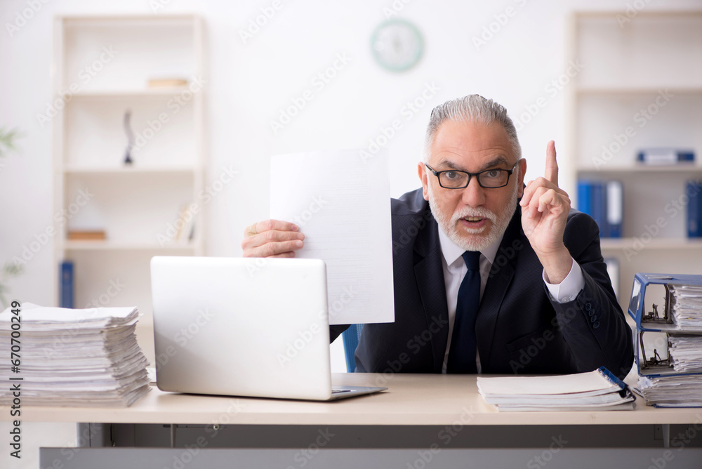 Fototapeta premium Old male employee working in the office