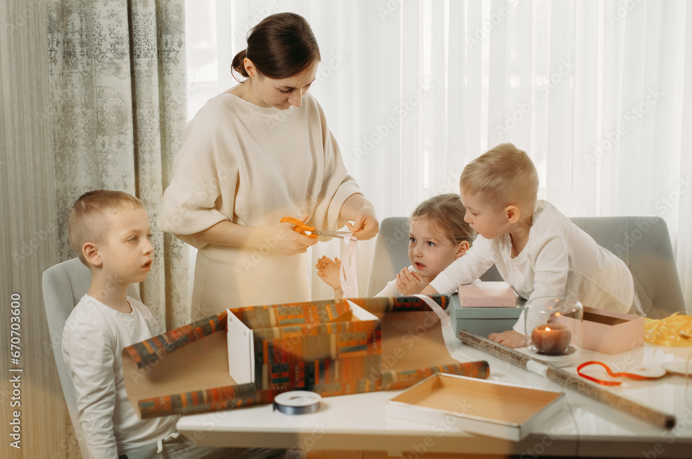 A mother and her children are preparing for Christmas, packing gifts. A mother and her children are preparing for Christmas, packing gifts.