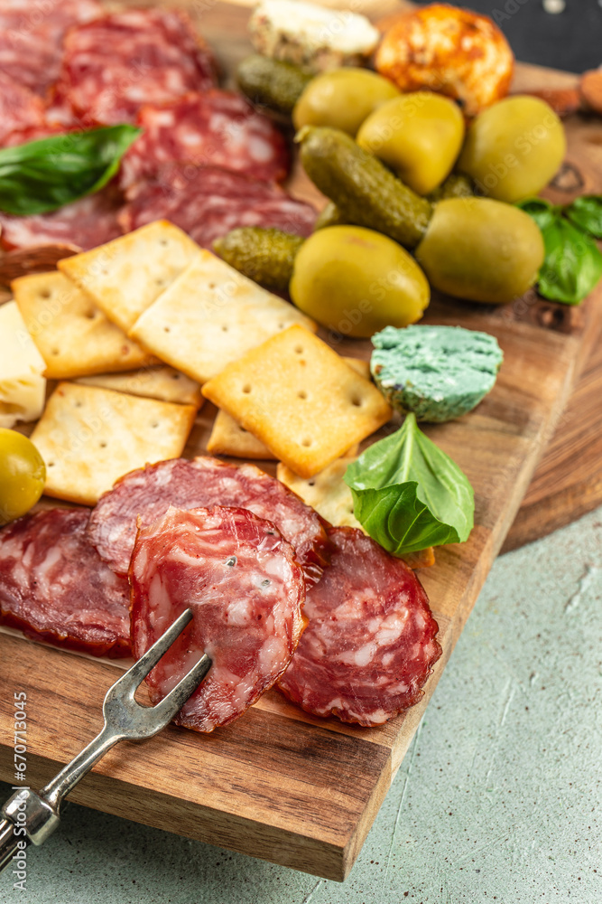 Appetizers table with different antipasti salami, cheese and olives on a light background top view. place for text Appetizers table with different antipasti salami, cheese and olives on a light background top view. place for text