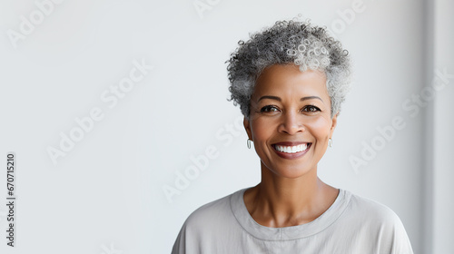 Beautiful black woman with smooth healthy facial skin. Beautiful aged mature woman with short gray hair and happy smile on a white background