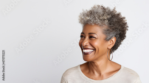 Beautiful black woman with smooth healthy facial skin. Beautiful aged mature woman with short gray hair and happy smile. Beauty and skin care cosmetics advertising concept. photo