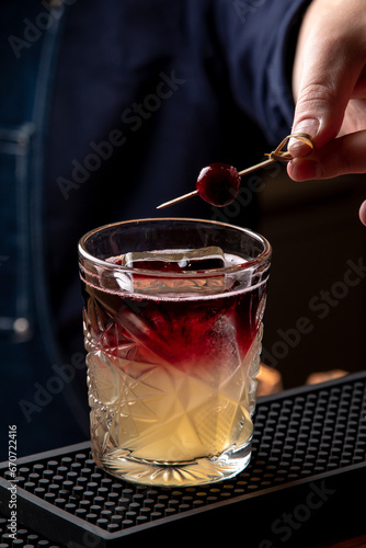 Bartender decorating a cocktail in a restaurant, close-up