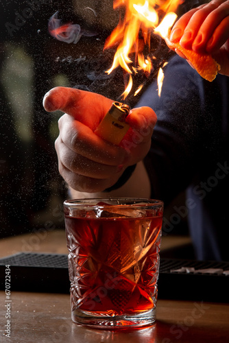 Bartender decorating a cocktail in a restaurant, close-up