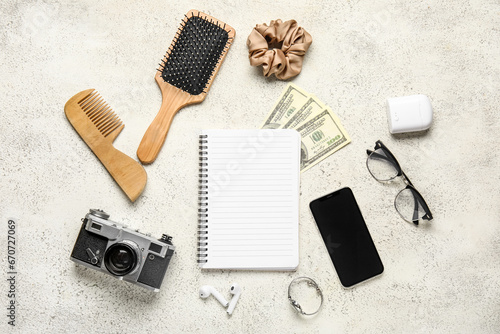 Composition with blank notebook, female accessories, money and gadgets on light background