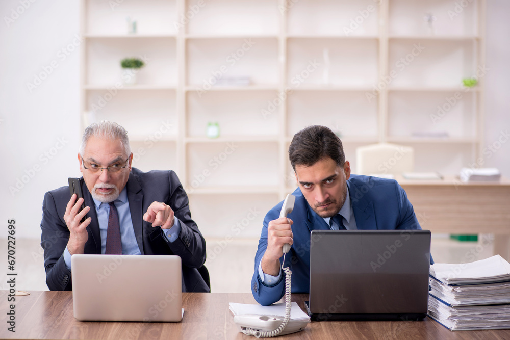Two male employees working in the office Two male employees working in the office