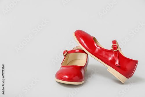 Pair of red child's shoes on grey background